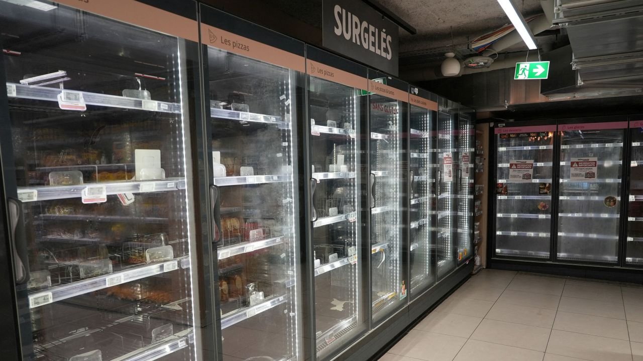 View of empty refrigerators in the frozen food aisle of an Intermarché supermarket in Paris on Tuesday, a day after a nationwide cyberattack on refrigeration systems caused food losses and fires at several stores.