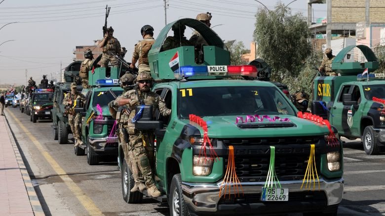 Members of the Iraqi security forces drive in a convoy through the city as they celebrate the withdrawal of US-led coalition forces from Iraq, ending a military presence that began after the 2003 US-led invasion, in Najaf, Iraq, September 30.