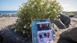 The photos of foreign surfers who disappeared are displayed on a poster on the beach in Ensenada, Mexico, on May 5, 2024.