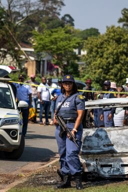 A police officer stands at the scene of a mass shooting at a house party in KwaMakhutha township, south of the city of Durban, South Africa, on September 23.