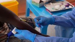 A doctor collects an participant's to test during clinical trials attempting to stop the rare Bundibugyo virus, amidst a deadly Ebola outbreak, in Rwampara Hospital in Ituri, Congo, on Thursday, Oct. 1.