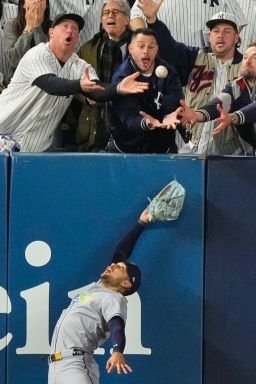 Tampa Bay Rays left fielder Victor Mesa Jr. makes an attempt on a ball interfered with by fans that umpires reviewed and ruled a run-scoring double by New York Yankees' Anthony Volpe.