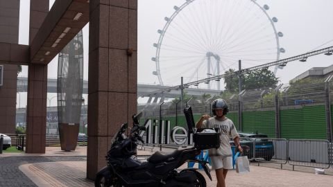 A man places bags in his motorcycle during a hazy day near the venue for the Singapore Formula One Grand Prix weekend at the Marina Bay Street Circuit in Singapore, Friday, Oct. 9, 2026.