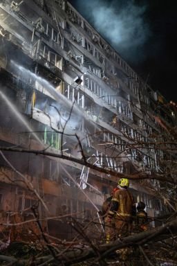 Ukrainian firefighters extinguish a blaze at the site of a Russian missile strike at an apartment building in Kyiv on October 14.
