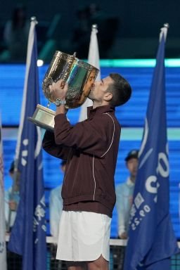 Serbia's Novak Djokovic holds up the trophy as he celebrates winning the men's singles final against Australia's Alex de Minaur at the China Open tennis tournament in Beijing on October 6, 2026.
