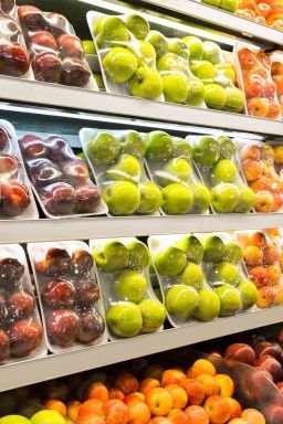 Assorted apple packages in a supermarket refrigerator.