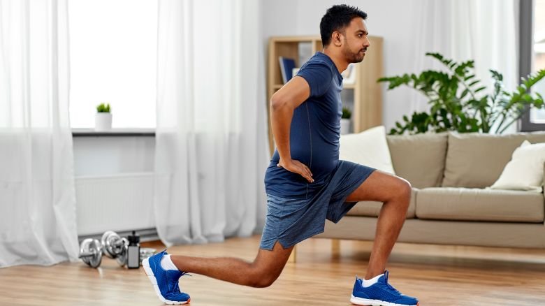 fitness, sport and healthy lifestyle concept - indian man exercising and doing lunge at home