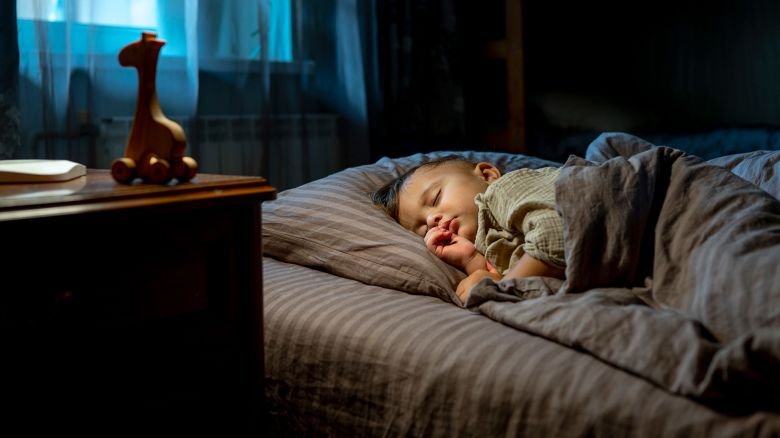 Cute baby boy sleeping on bed