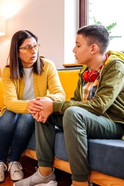 Mother trying to explain to her teenager son how he should behave better and trying to understand him with giving him mental support
