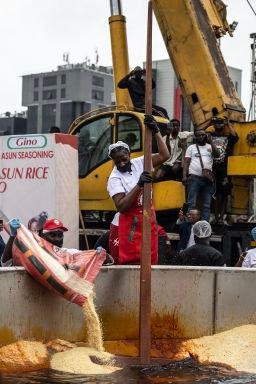 Nigerian chef Hilda Baci (C) stirs as staff members pour rice in a giant pot during an attempt to break the world record for the largest pot of Jollof rice, led by Baci in Lagos, on September 12, 2025.