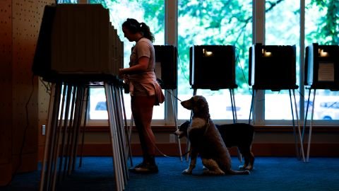 Danielle Grisolano and her dogs, Lincoln and Pepper, vote in Colorado's primary election at the Central Library in Denver, on June 30.