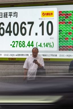 Pedestrians in front of an electronic quotation board displaying the Nikkei Stock Average on the Tokyo Stock Exchange on Friday.