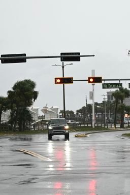 A car drives along a road in Pensacola Beach, Florida, on October 9, 2026, as Hurricane Isaias moves north toward the Florida Panhandle. Hurricane Isaias intensified to Category 2 in the Gulf of Mexico's warm waters on Thursday as it churned toward the southern United States, the National Hurricane Center (NHC) said. The first hurricane of the Atlantic season, Isaias is forecast to make landfall in Florida, Alabama or Mississippi overnight Friday to Saturday, according to the NHC.