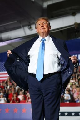 President Donald Trump opens up his suit jacket as he wraps up a campaign rally in Grand Island, Nebraska, on October 5, 2026.