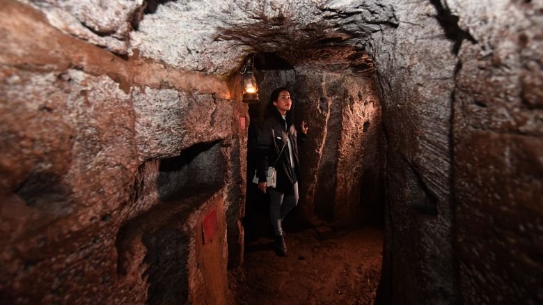 In this picture taken on January 18, 2018, a guide walks through the Vinh Moc tunnel network, at the Vinh Moc commune in the central coastal province of Quang Tri. The Vinh Moc tunnels are among thousands of underground passageways built across Vietnam throughout the war, including the massive Cu Chi tunnels in Saigon, where Viet Cong guerrillas took shelter beneath the former Southern capital, which was renamed Ho Chi Minh city after the war's end in 1975. (Photo by HOANG DINH Nam / AFP via Getty Images) / TO GO WITH Vietnam-US-War-History by Jenny VAUGHAN